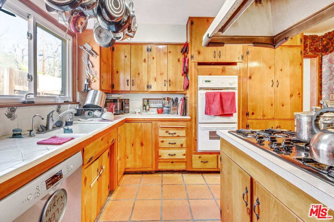 4183 Aralia Road Altadena, CA 91001 - Photo 19 of 40 a kitchen with stainless steel appliances a sink and a stove