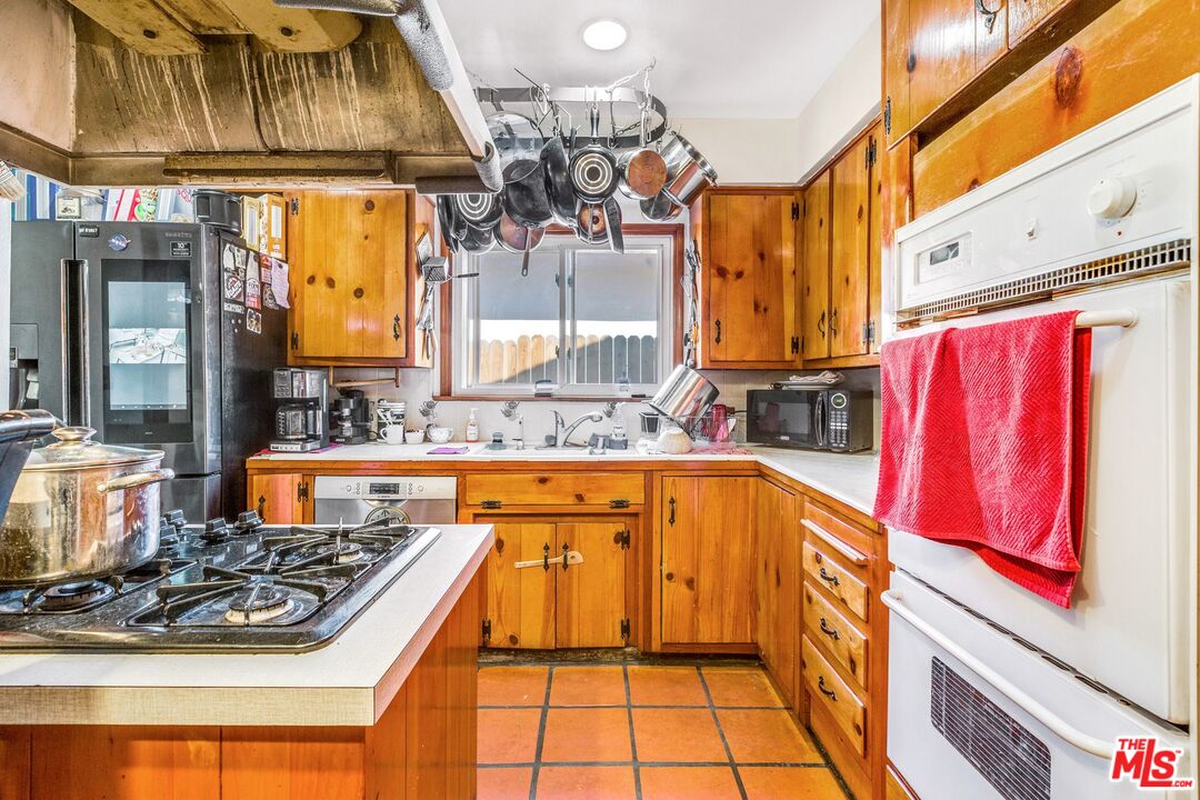 4183 Aralia Road Altadena, CA 91001 - Photo 24 of 40 a kitchen with stainless steel appliances granite countertop a stove a sink and a microwave