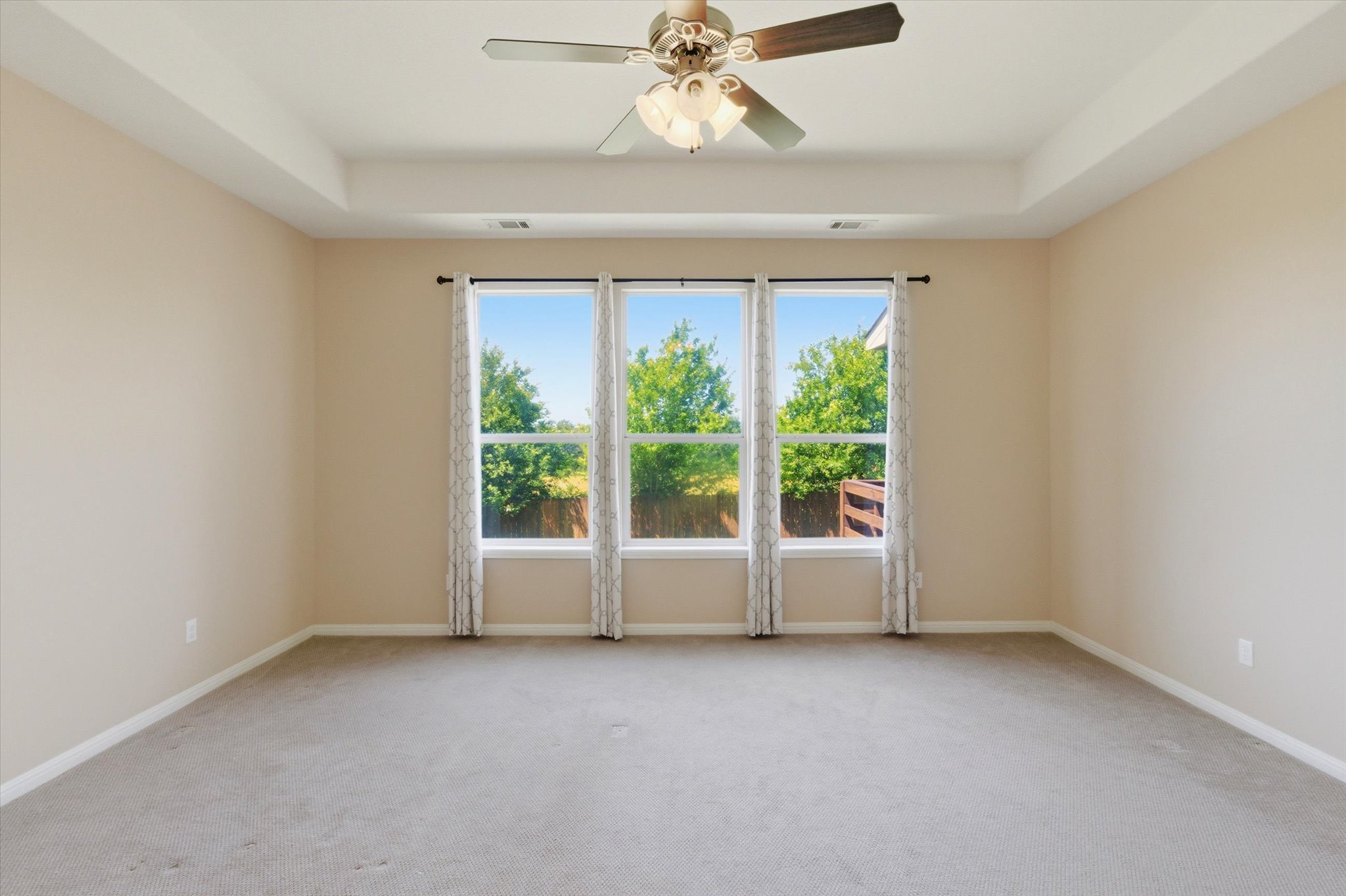 1511 Rimstone Drive Cedar Park, TX 78613 - Photo 18 of 39 A spacious primary bedroom features tray ceilings, soft carpeting, and abundant natural light from a trio of windows.