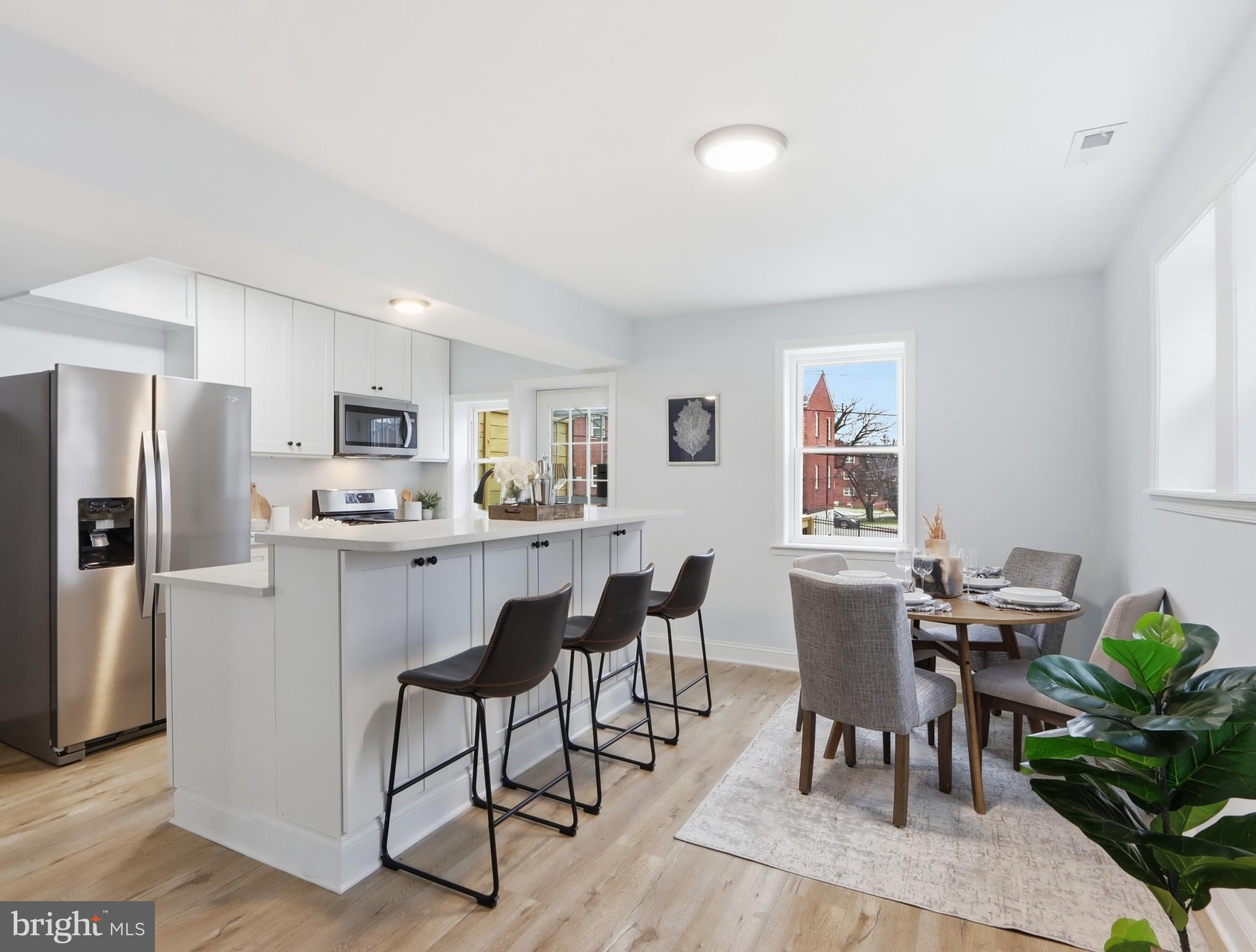 932 East 41st Street Baltimore, MD 21218 - Photo 12 of 51 a kitchen with white cabinets and stainless steel appliances