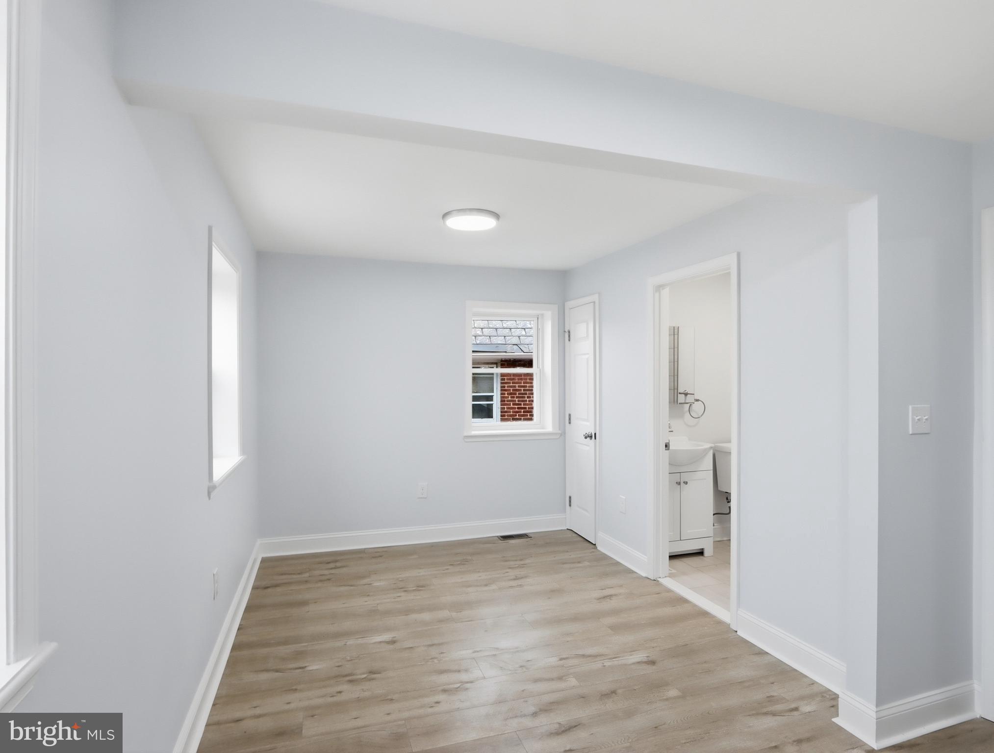 932 East 41st Street Baltimore, MD 21218 - Photo 17 of 51 an empty room with wooden floor and windows