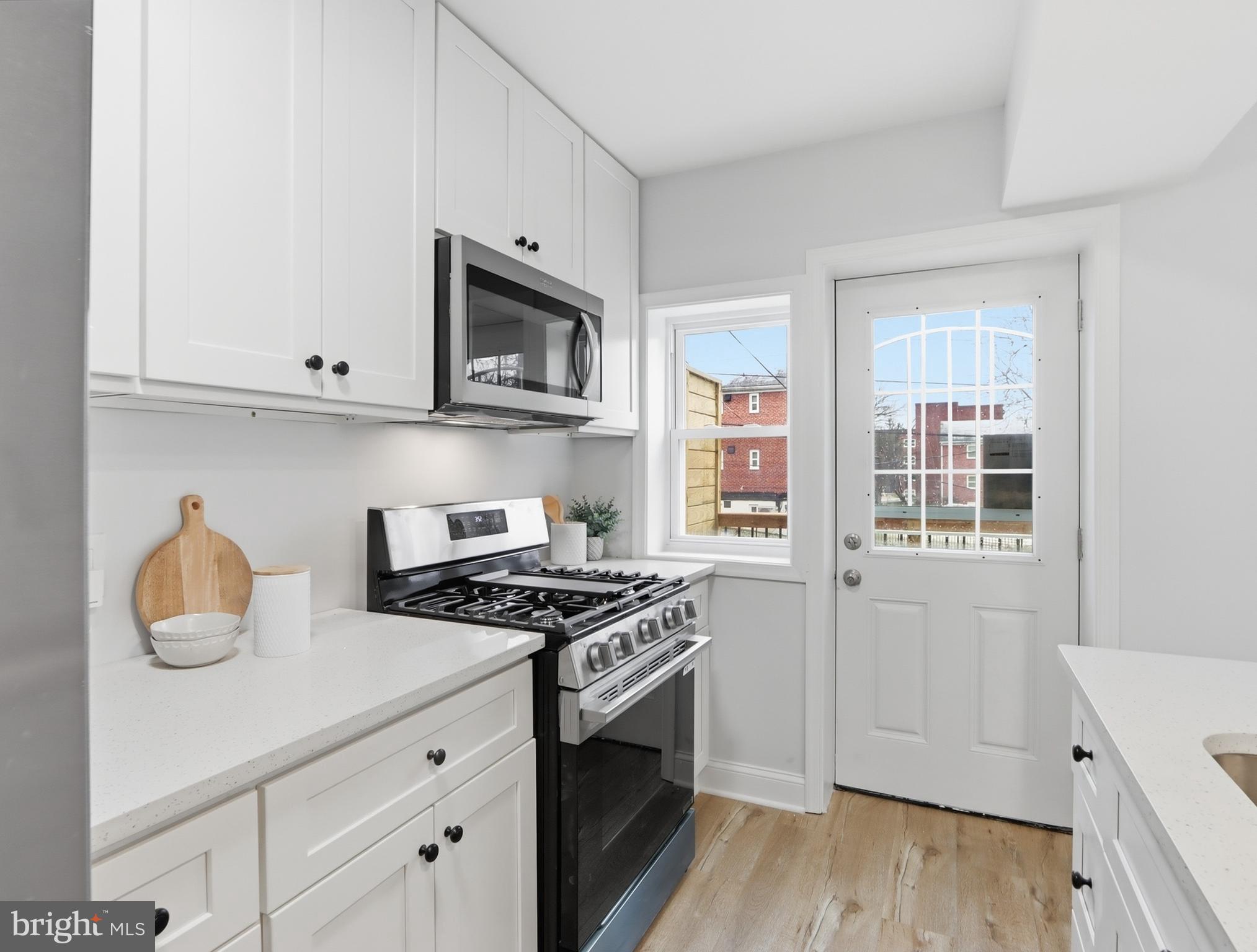 932 East 41st Street Baltimore, MD 21218 - Photo 32 of 51 a kitchen with stainless steel appliances granite countertop white cabinets and a stove top oven