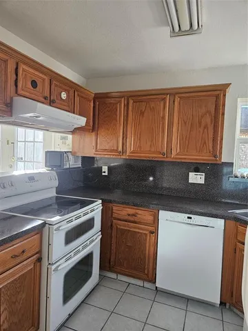 a kitchen with granite countertop a stove sink and cabinets