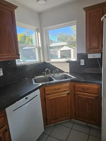 a kitchen with granite countertop sink stove and cabinets