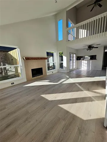 a living room with a fireplace furniture a ceiling fan and a window