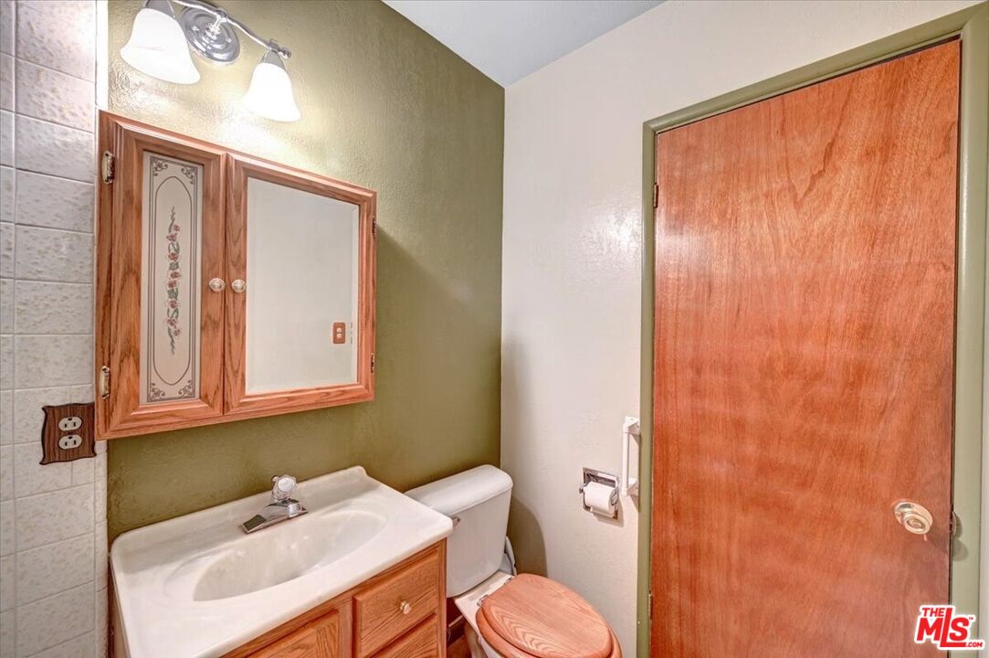 13611 Daventry Street Pacoima, CA 91331 - Photo 22 of 43 a bathroom with a sink a toilet and shower curtain