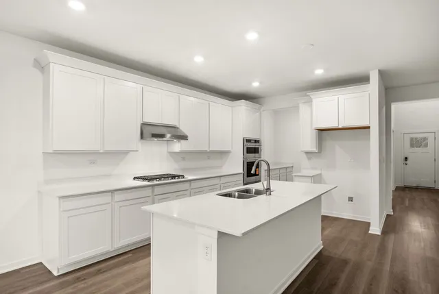 a kitchen with a sink white cabinets and white appliances