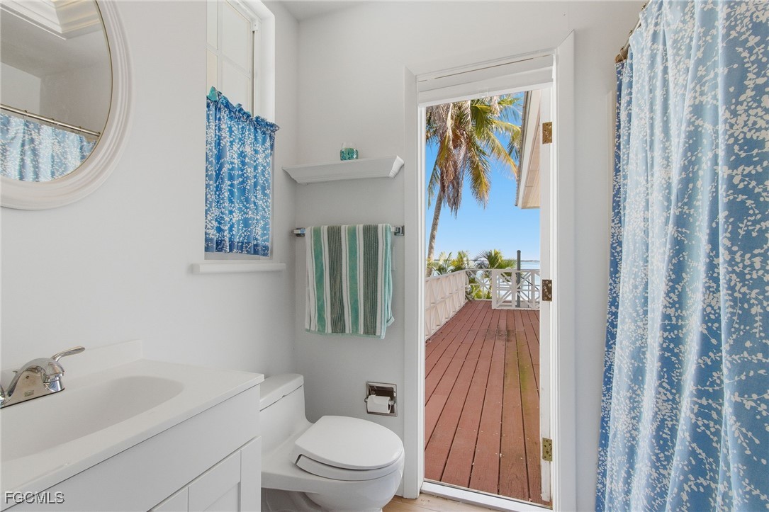 115 Useppa Island Bokeelia, FL 33922 - Photo 30 of 38 a bath room with a toilet a sink and a mirror