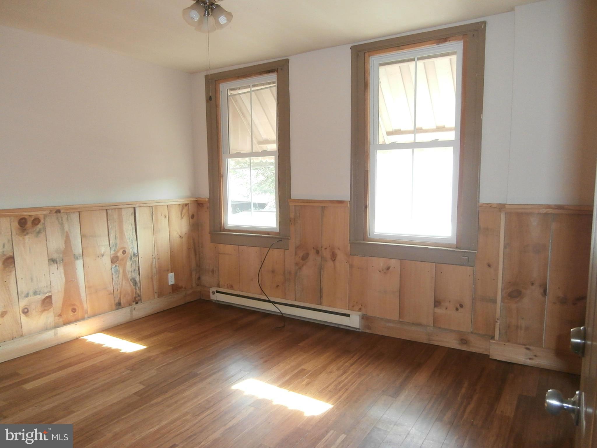 10 Blue Ridge Avenue, Unit 1 Front Royal, VA 22630 - Photo 2 of 7 an empty room with wooden floor and windows