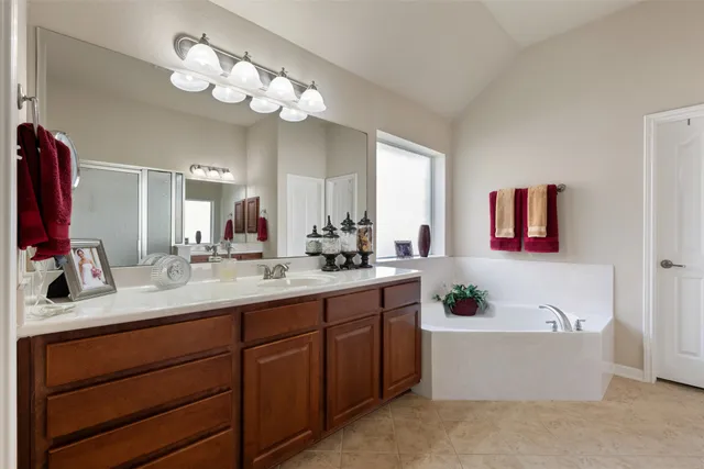 a spacious bedroom with a bed and a chandelier