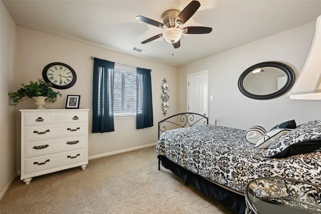a bedroom with a bed a chandelier and dresser