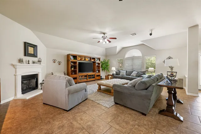 a large living room with stainless steel appliances furniture a couch and a view of kitchen