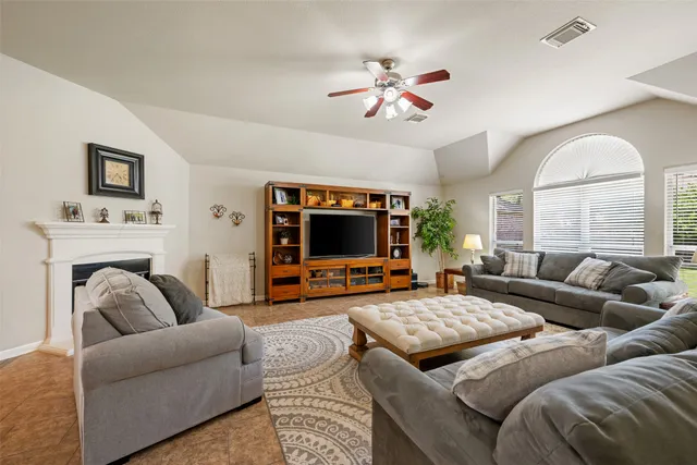 a living room with furniture a fireplace and a flat screen tv