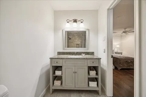a bathroom with a granite countertop sink and a mirror