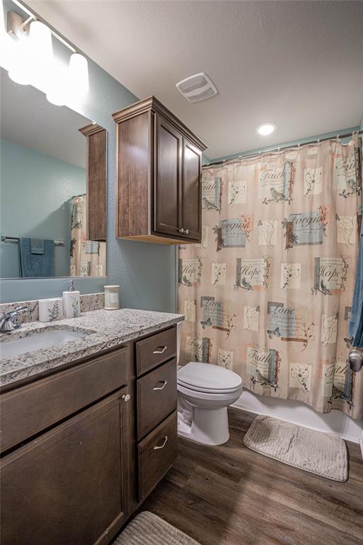 4028 Bravo Ranch Road Waco, TX 76705 - Photo 11 of 19 a bathroom with a granite countertop sink a toilet a mirror and shower
