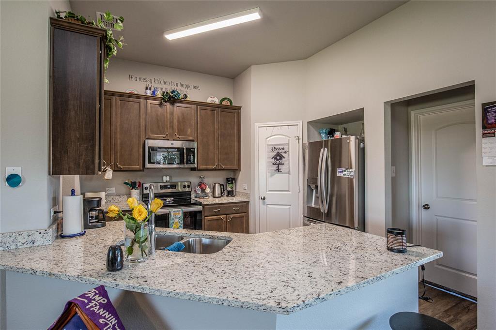 4028 Bravo Ranch Road Waco, TX 76705 - Photo 4 of 19 a kitchen with kitchen island granite countertop a sink stove and refrigerator