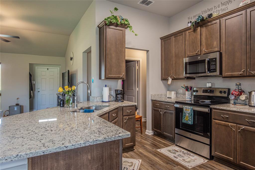 4028 Bravo Ranch Road Waco, TX 76705 - Photo 5 of 19 a kitchen with stainless steel appliances granite countertop a sink stove and refrigerator