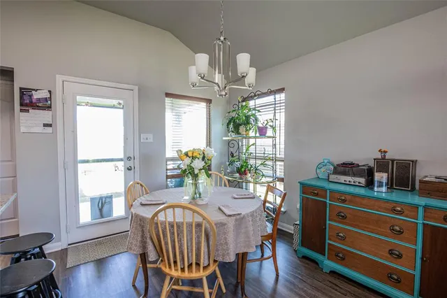 a dining room with furniture a chandelier and wooden floor