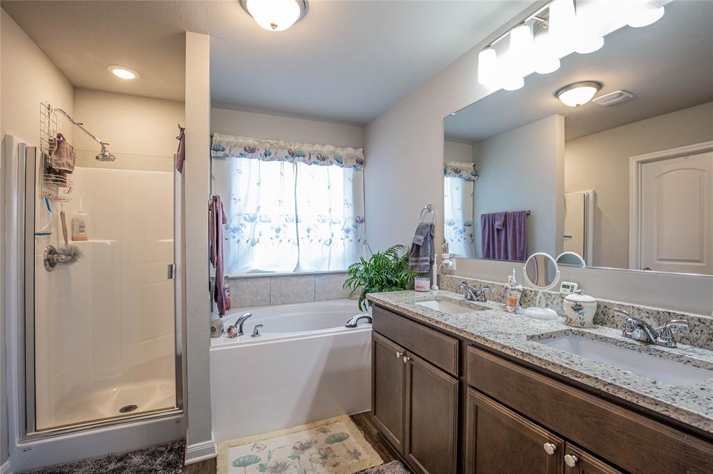 4028 Bravo Ranch Road Waco, TX 76705 - Photo 9 of 19 a bathroom with a granite countertop tub sink shower and mirror