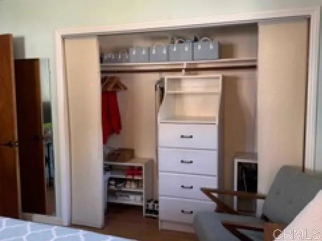 a view of walk in closet with clothes and shoes