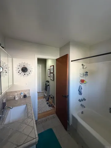 a bathroom with a tub a sink and glass door