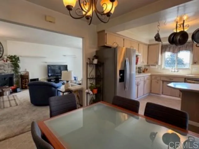 a living room with stainless steel appliances granite countertop furniture a rug a lamp and a window