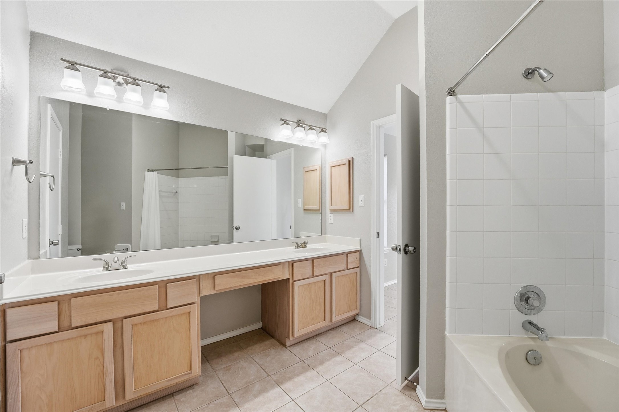 2618 Heather Knoll Drive Spring, TX 77373 - Photo 23 of 32 a bathroom with a double vanity sink a large mirror and a bathtub