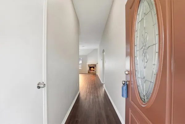 a view of a hallway with wooden floor and staircase