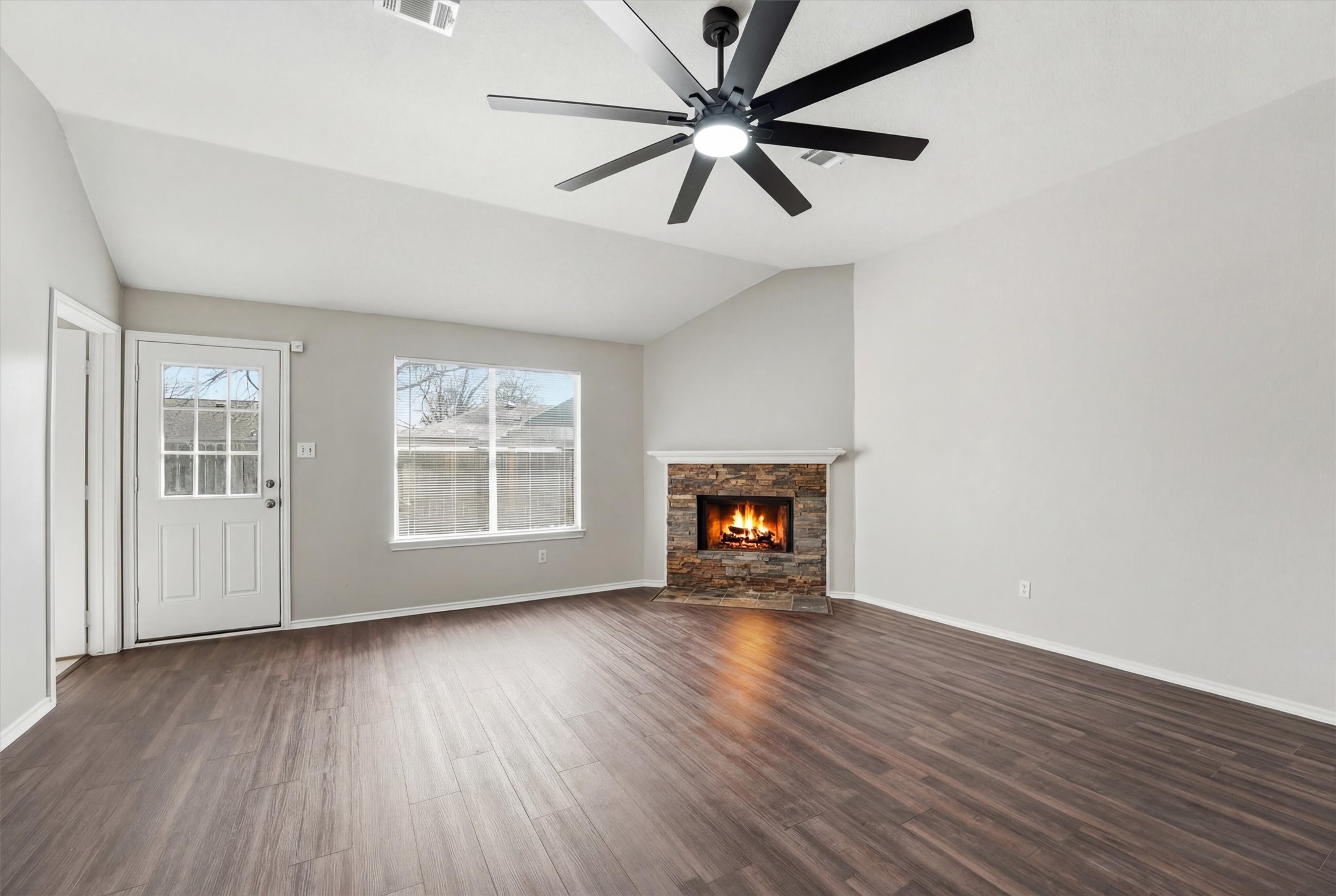 2618 Heather Knoll Drive Spring, TX 77373 - Photo 9 of 32 an empty room with wooden floor chandelier fan and windows