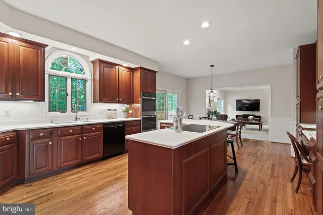 a kitchen with stainless steel appliances kitchen island granite countertop a sink stove and refrigerator