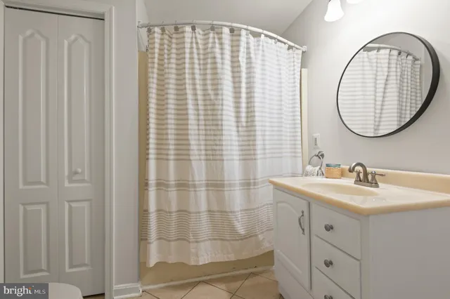 a bathroom with a sink a mirror and a shower curtain