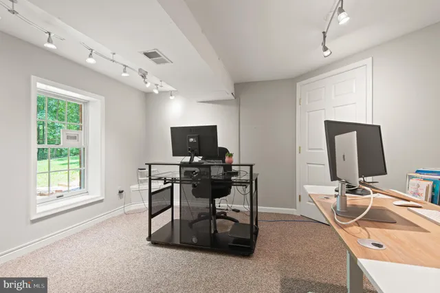 a view of a workspace with furniture and a window
