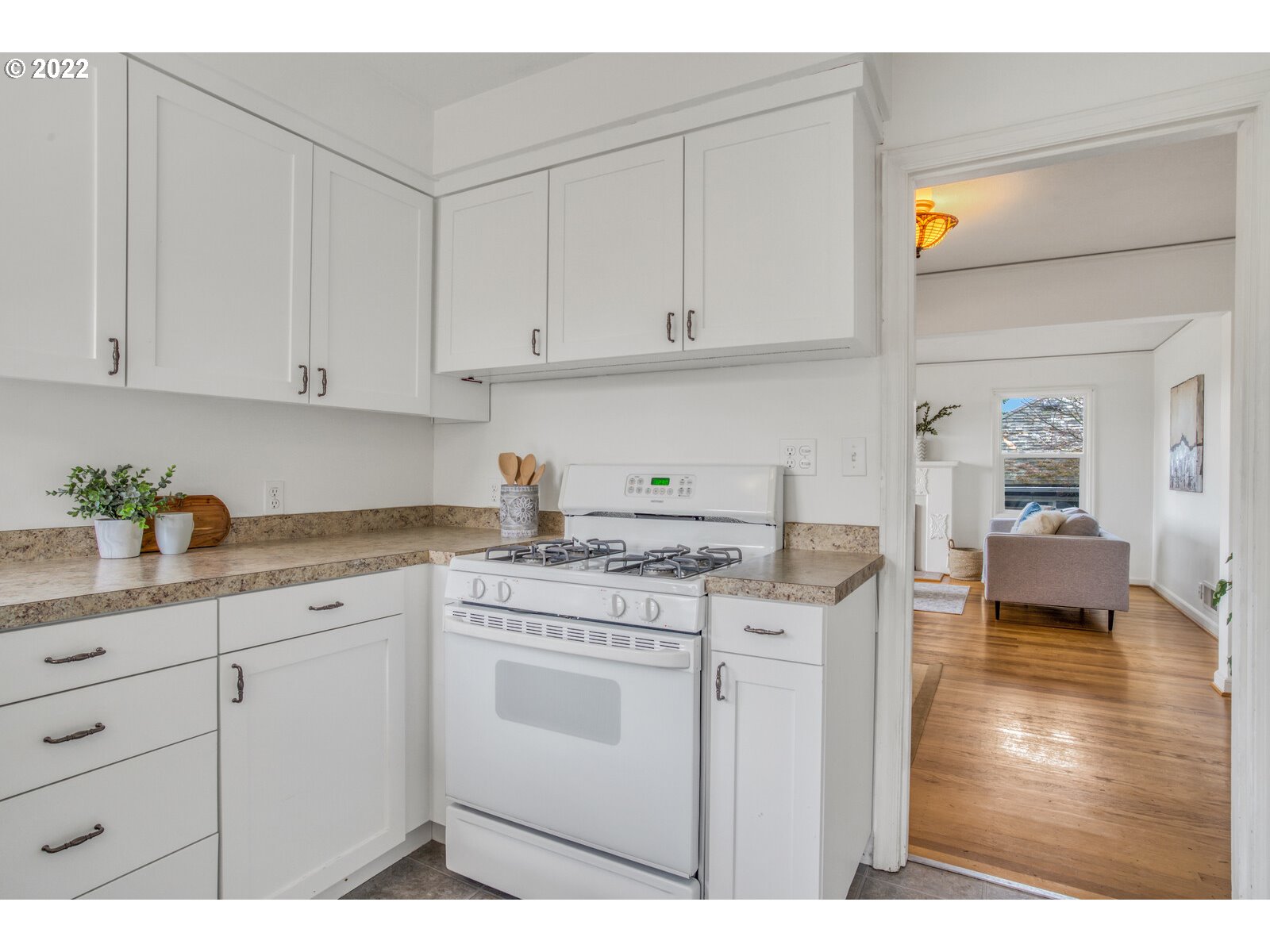 3330 Southwest Primrose Street Portland, OR 97219 - Photo 11 of 26 a kitchen with stainless steel appliances granite countertop a stove a sink and white cabinets