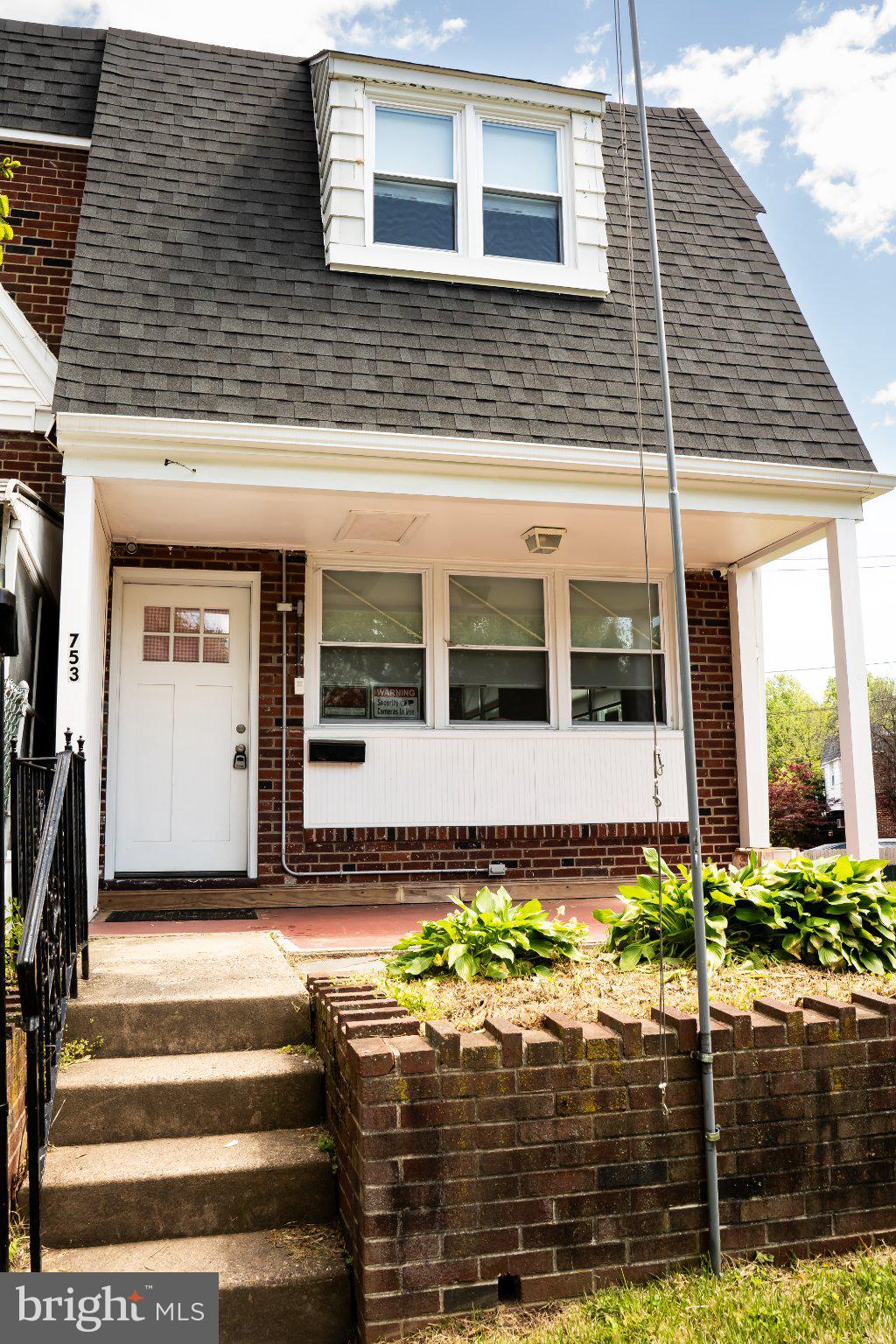 Charming brick home with inviting porch.
