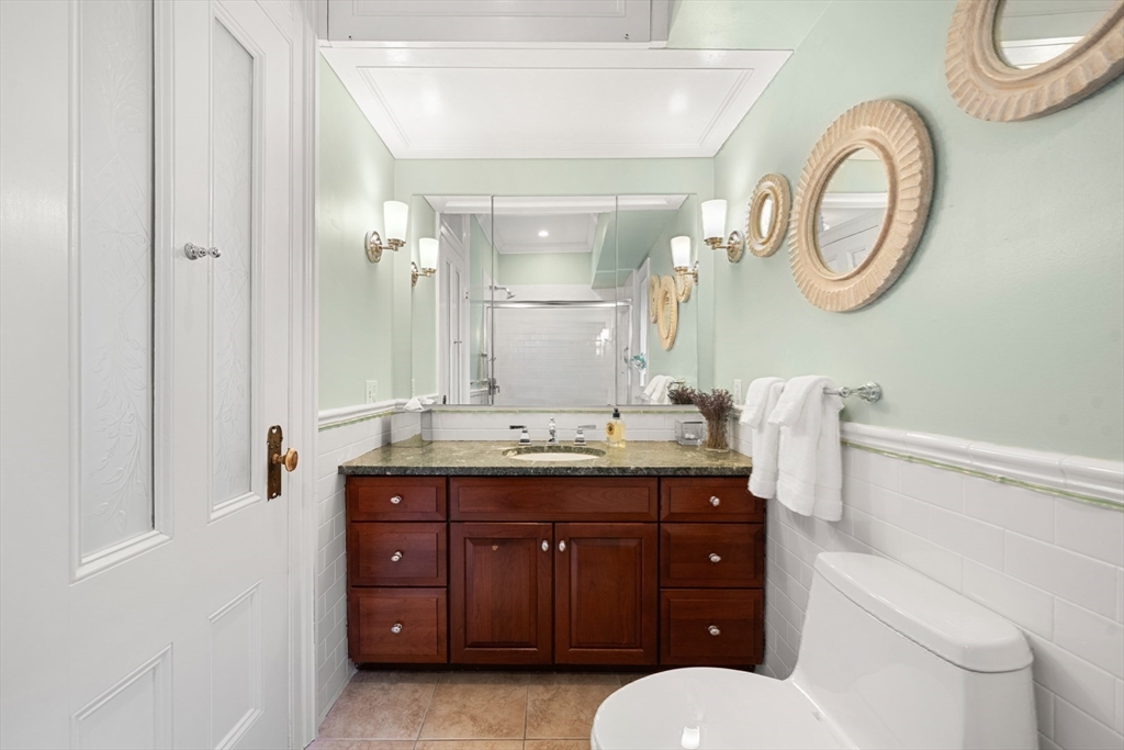 54 Union Park Boston, MA 02116 - Photo 18 of 35 a bathroom with a granite countertop toilet a sink and a mirror