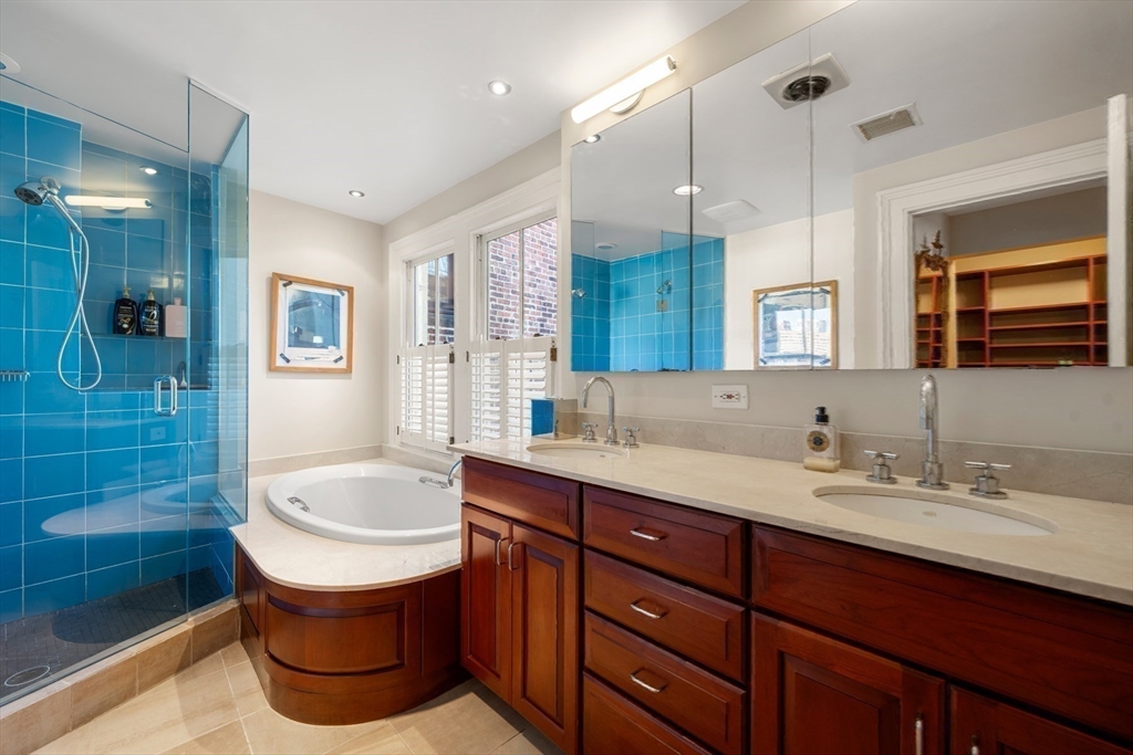 54 Union Park Boston, MA 02116 - Photo 25 of 35 a bathroom with a sink a bathtub a mirror a vanity and shower