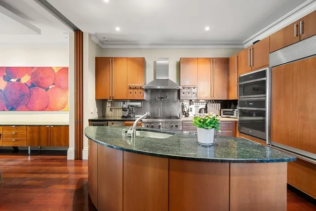 a view of a dining room and livingroom with furniture wooden floor and a chandelier