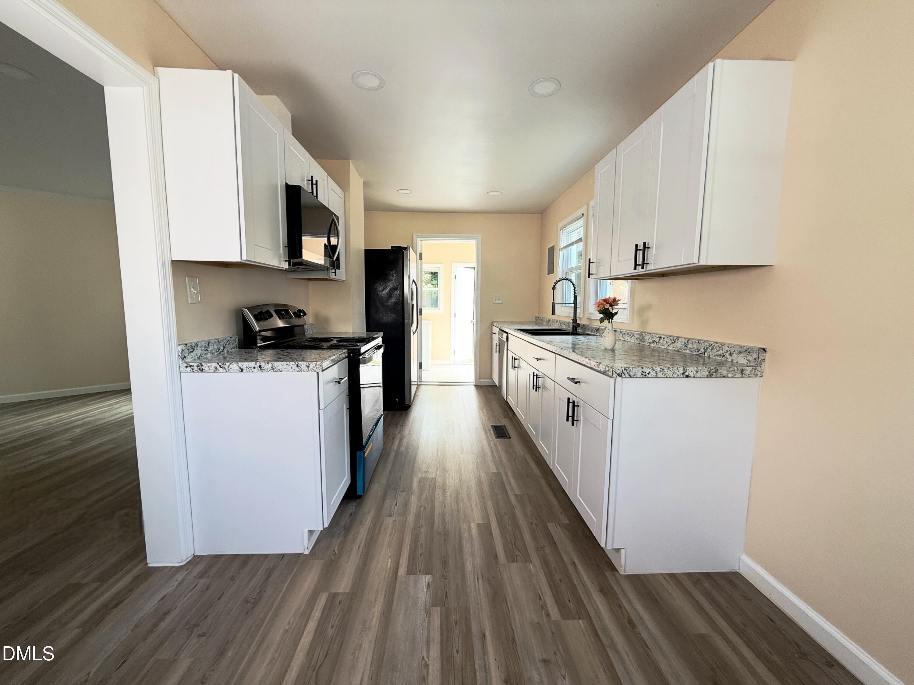 417 North Street Graham, NC 27253 - Photo 9 of 18 a kitchen with a sink a stove top oven and wooden floor