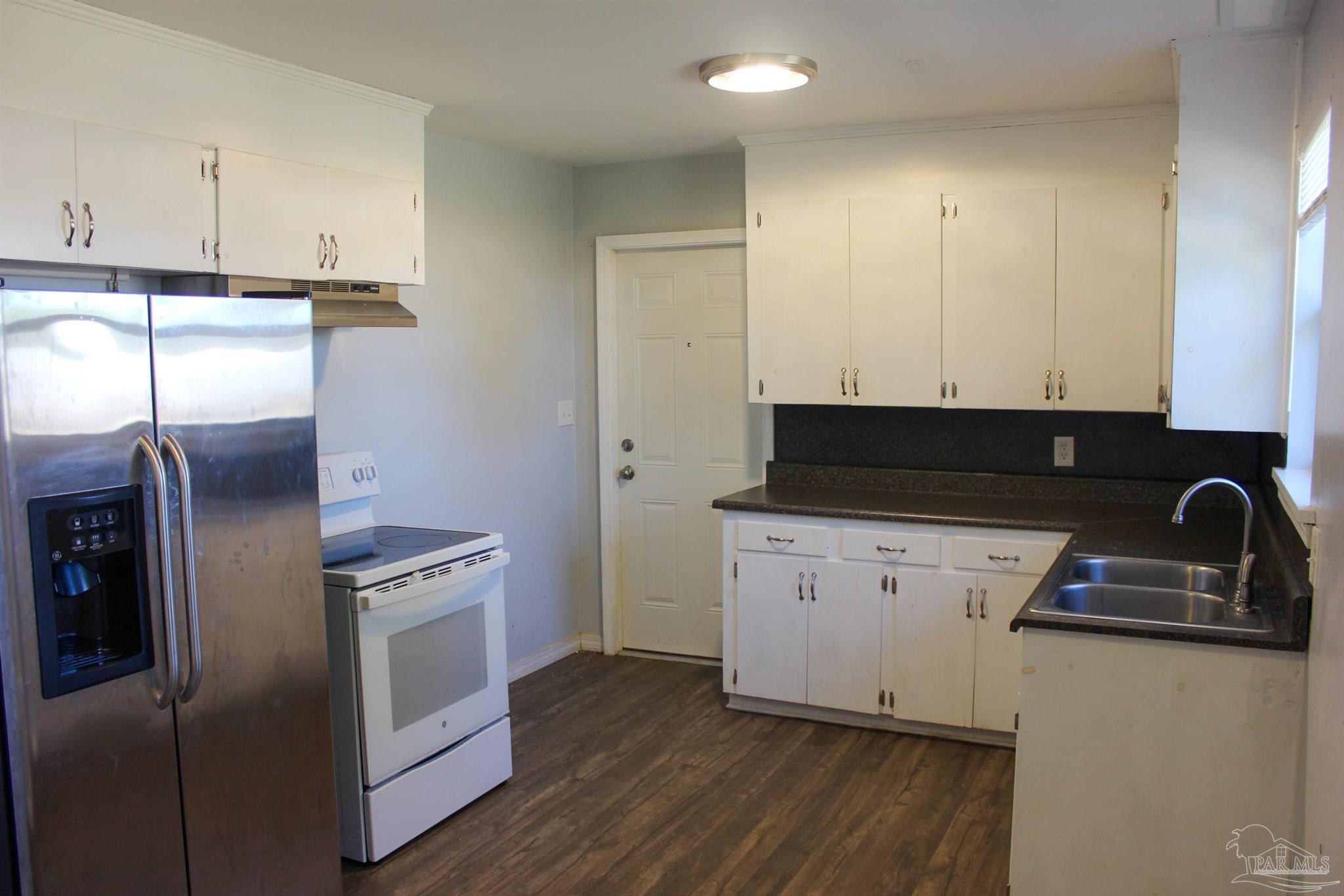 141 Holt Street Flomaton, AL 36441 - Photo 16 of 28 a kitchen with stainless steel appliances granite countertop a stove a refrigerator and a sink