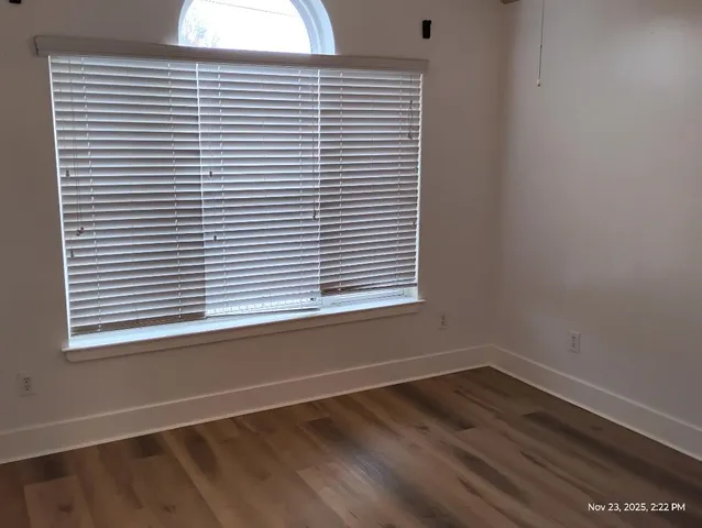 a view of a small space with wooden floor and a window
