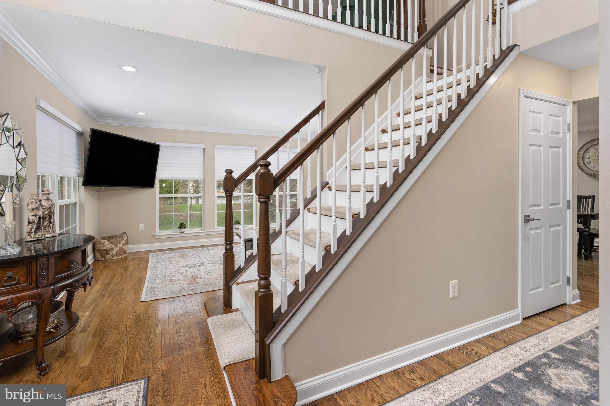 243 Colt Street Pennington, NJ 08534 - Photo 18 of 46 a living room with stairs and a flat screen tv