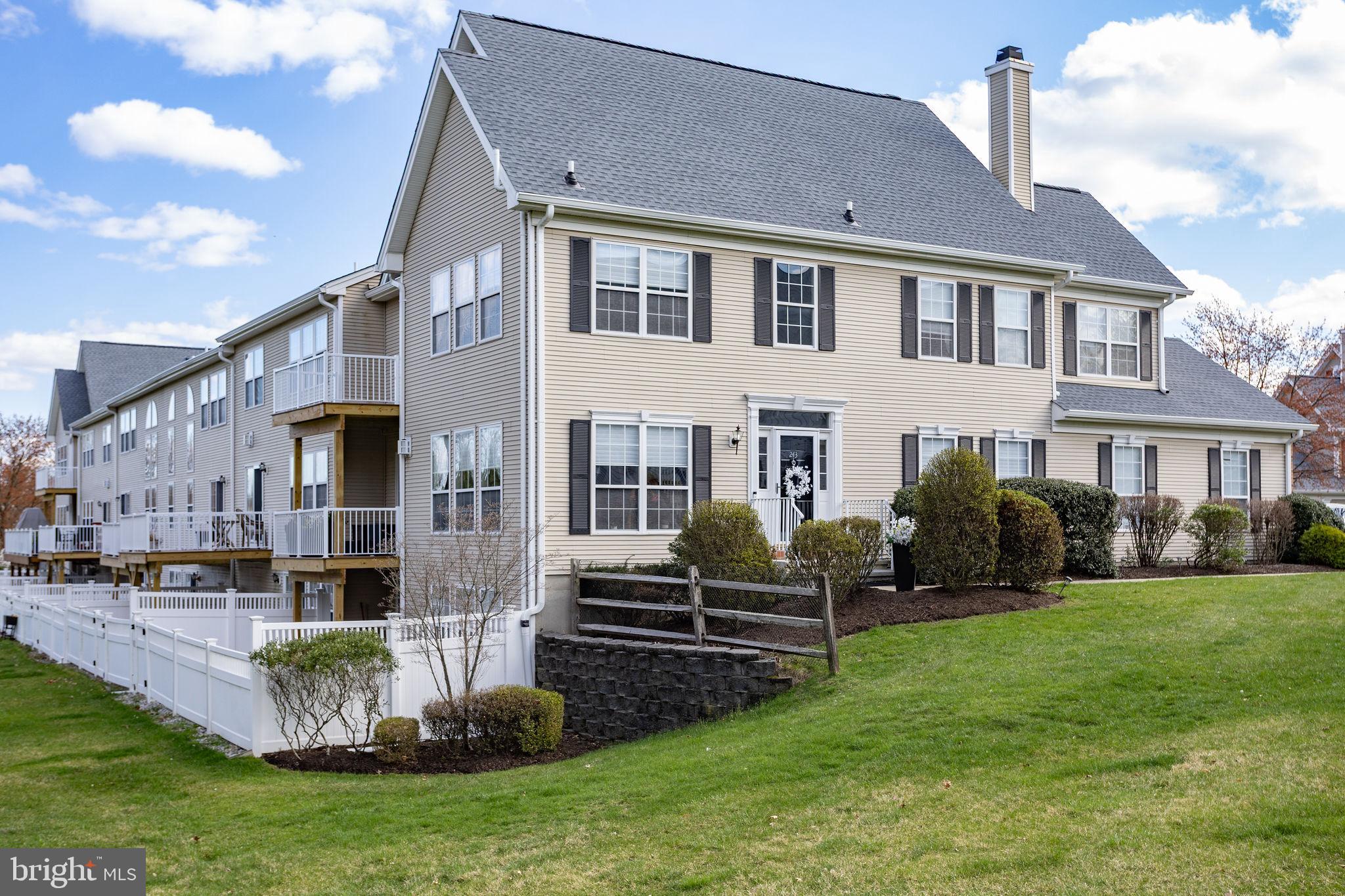 243 Colt Street Pennington, NJ 08534 - Photo 2 of 46 a front view of a house with a garden and plants
