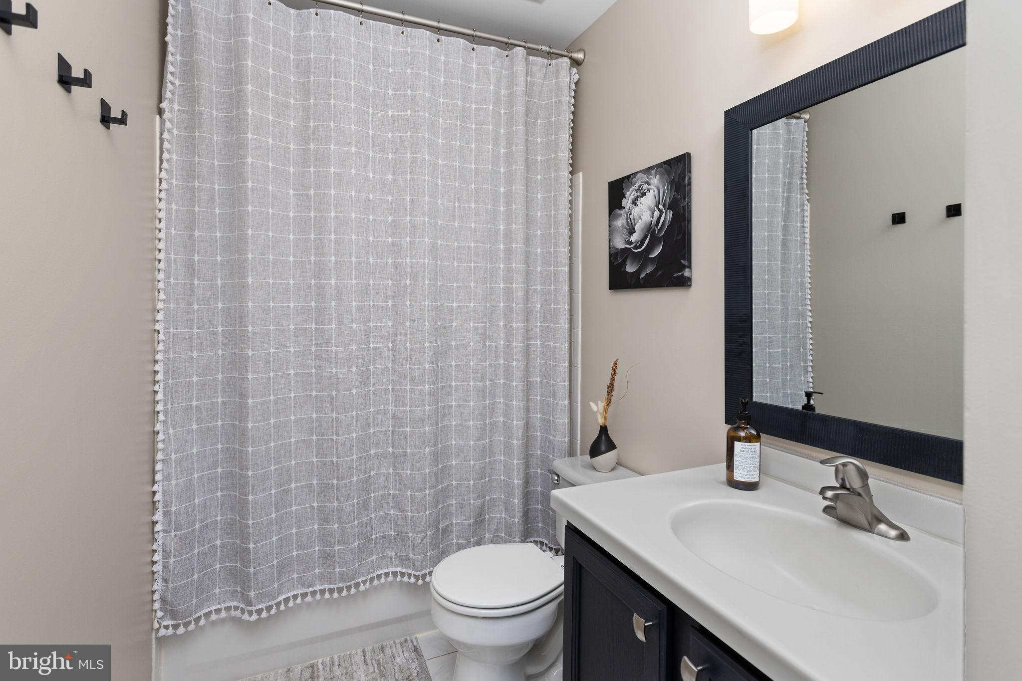 243 Colt Street Pennington, NJ 08534 - Photo 35 of 46 a bathroom with a sink a toilet and shower curtain