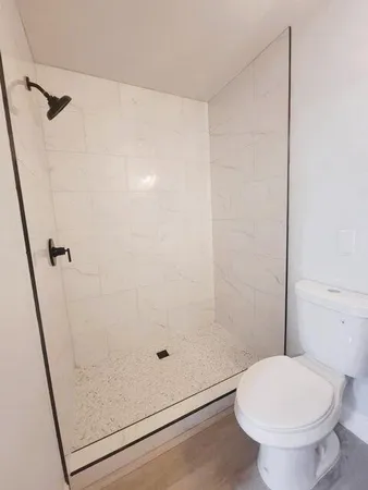 a bathroom with a toilet and a shower