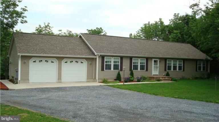 6125 Timber Ridge Road Berkeley Springs, WV 25411 - Photo 1 of 24 a front view of a house with a garden and trees