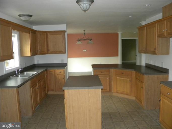 6125 Timber Ridge Road Berkeley Springs, WV 25411 - Photo 4 of 24 a kitchen with stainless steel appliances granite countertop a sink and a stove