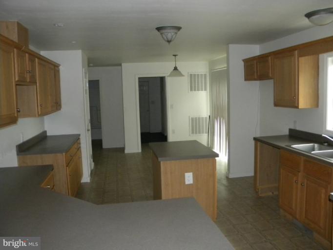 6125 Timber Ridge Road Berkeley Springs, WV 25411 - Photo 5 of 24 a kitchen with stainless steel appliances granite countertop a refrigerator a stove and a sink