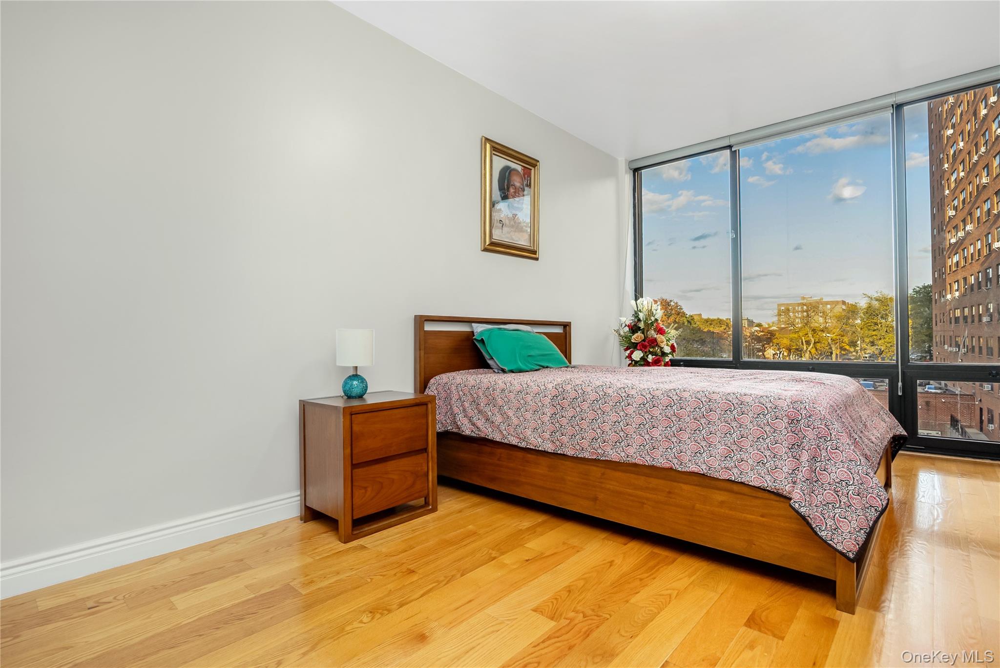 63-36 99th Street, Unit 4F Queens, NY 11374 - Photo 13 of 21 a bedroom with a bed mirror and window