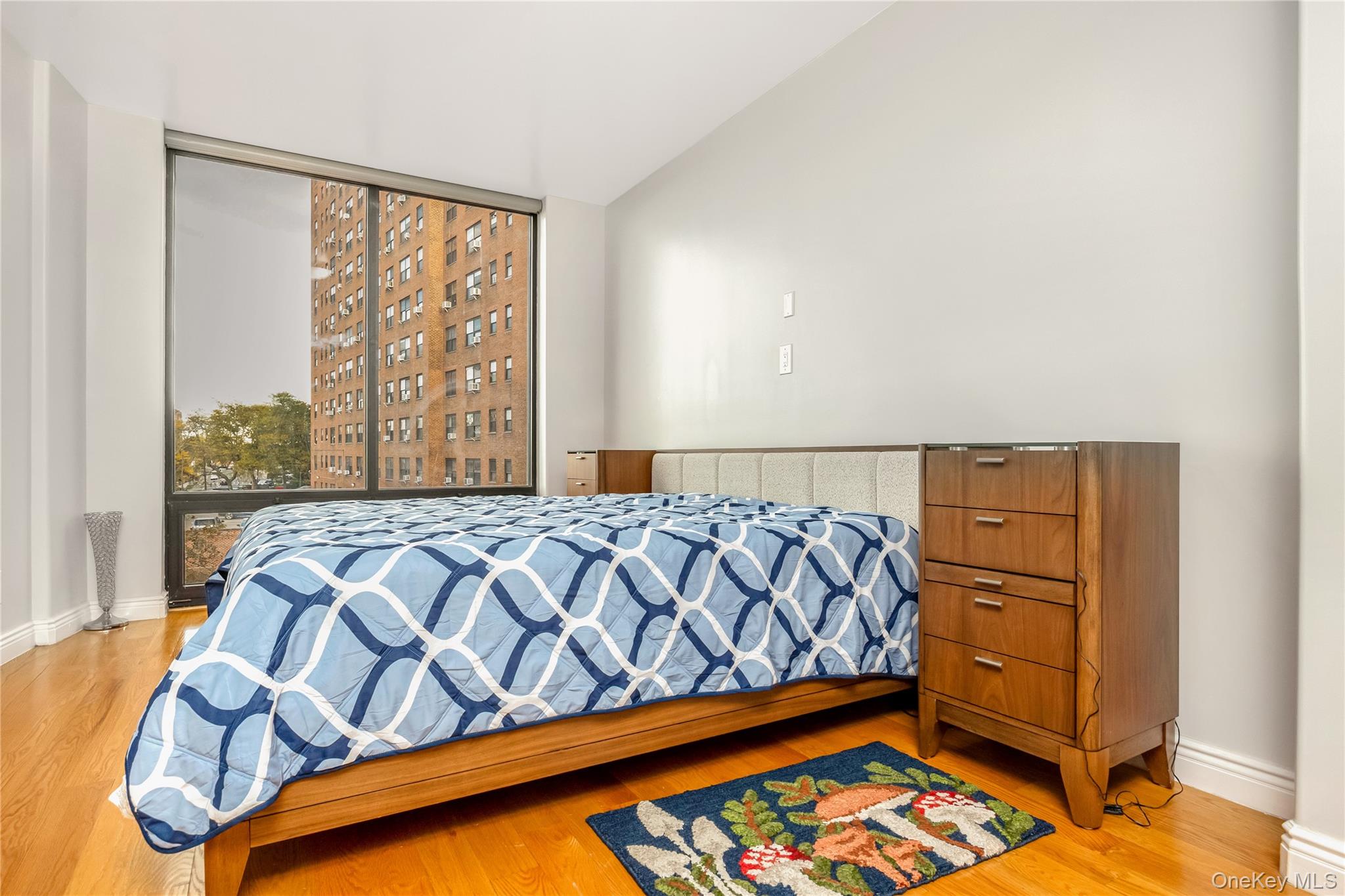 63-36 99th Street, Unit 4F Queens, NY 11374 - Photo 15 of 21 a bedroom with a bed and wooden floor
