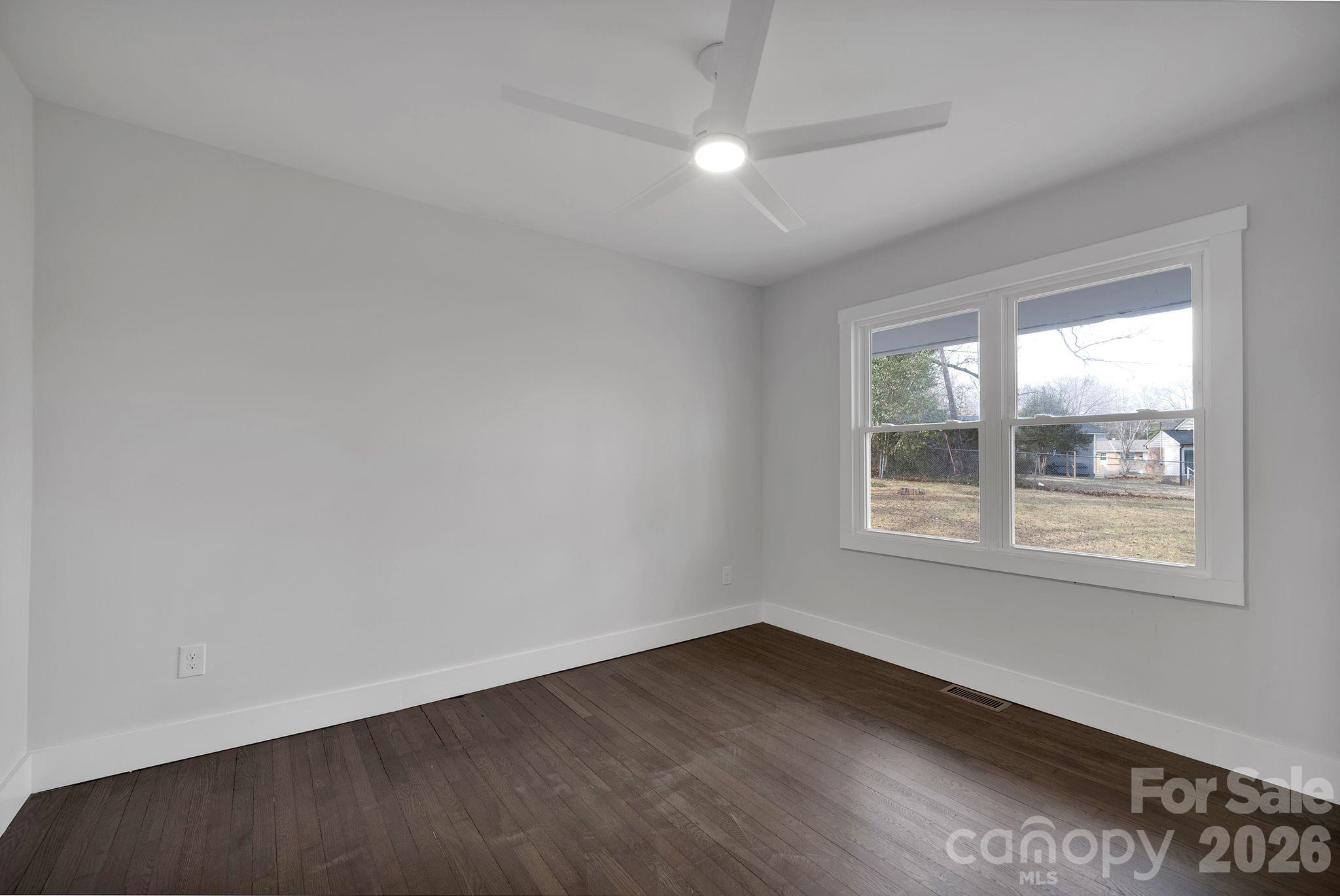 5413 Ruth Drive Charlotte, NC 28215 - Photo 18 of 29 an empty room with wooden floor and windows